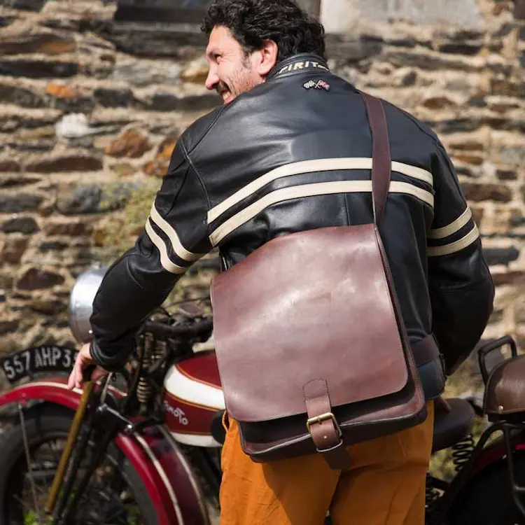 Homme portant une sacoche Baroudeur en cuir marron à bandoulière.